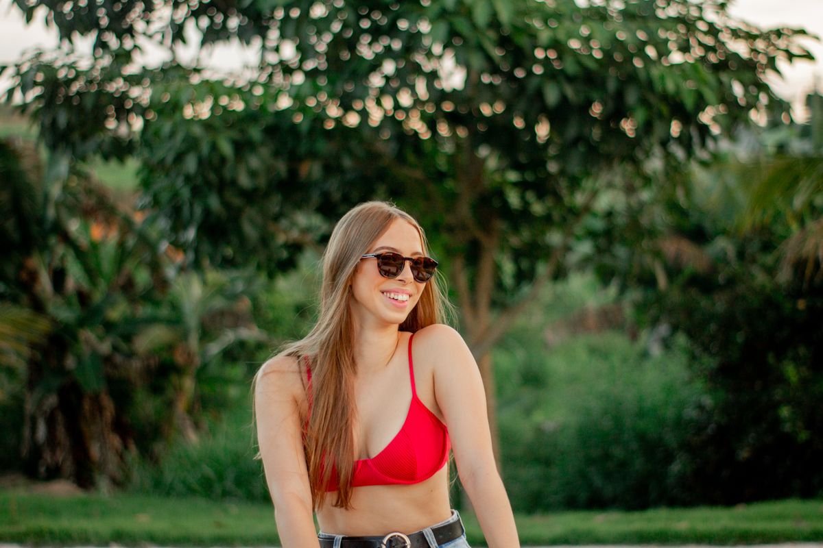 Young woman starting out, smiling hopefully at her laptop.