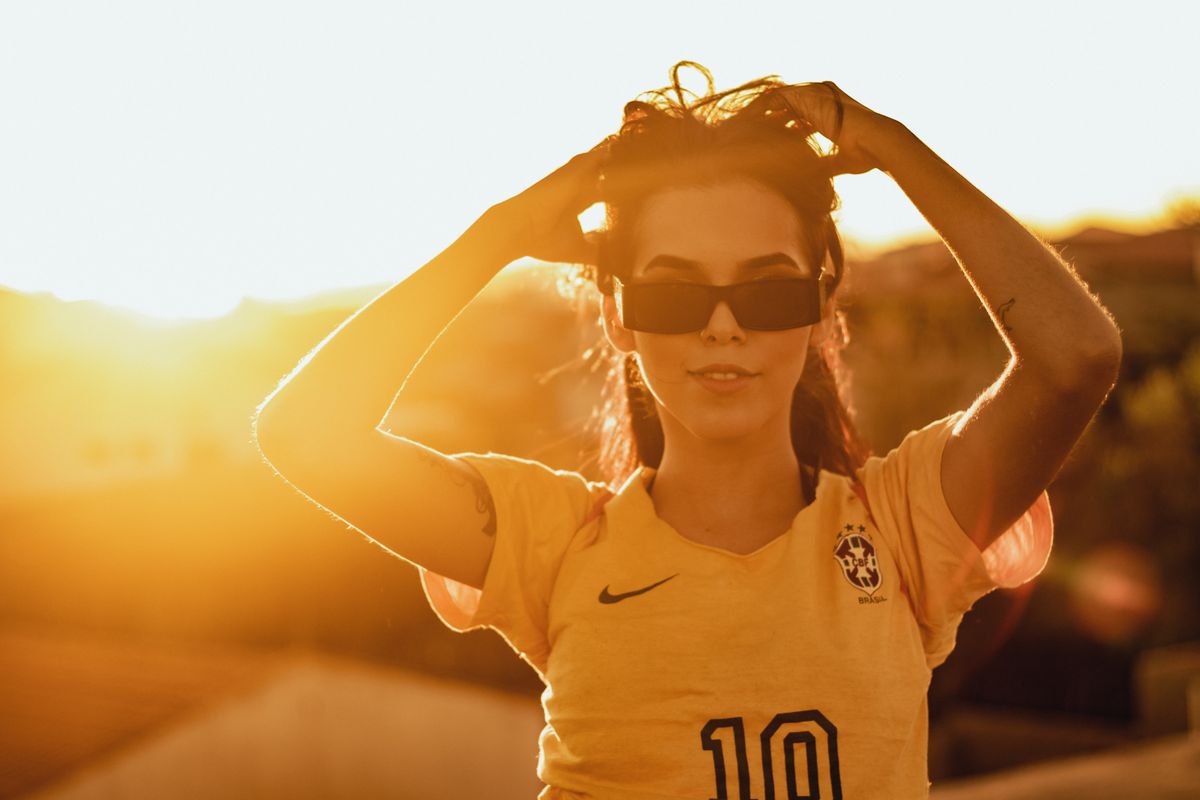 Young woman with a US city backdrop, using her phone confidently.